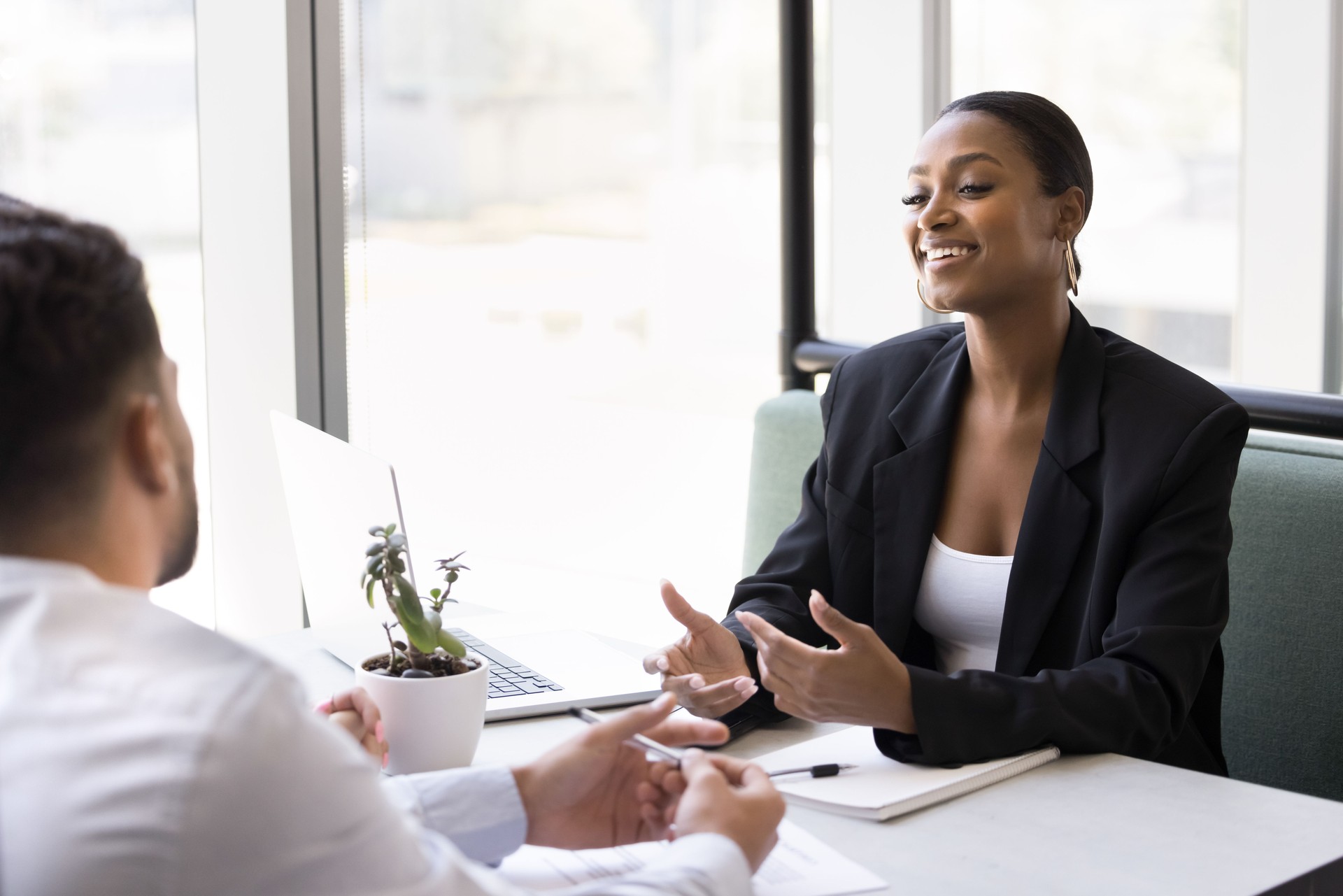 Smiling young businesswoman hold casual conversation with partners in cafe